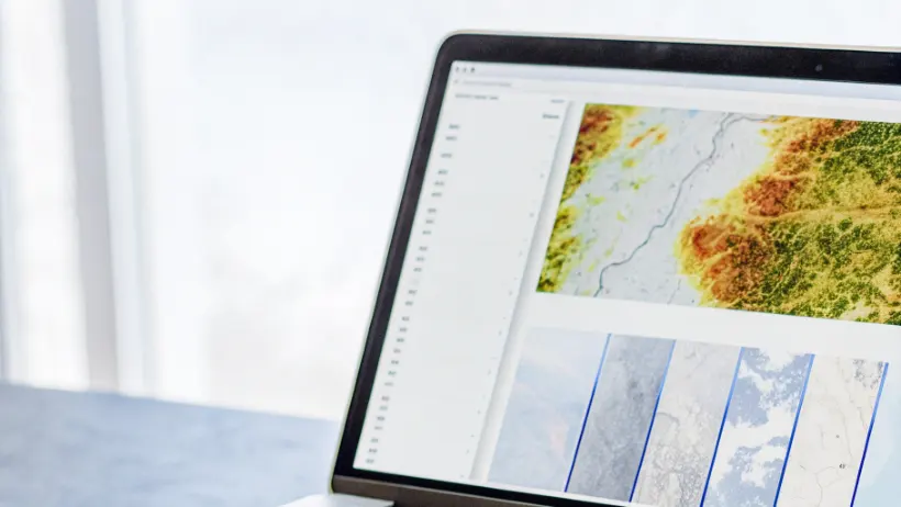 Computer screen displaying neural network processing layers analyzing satellite imagery with colorful data visualizations